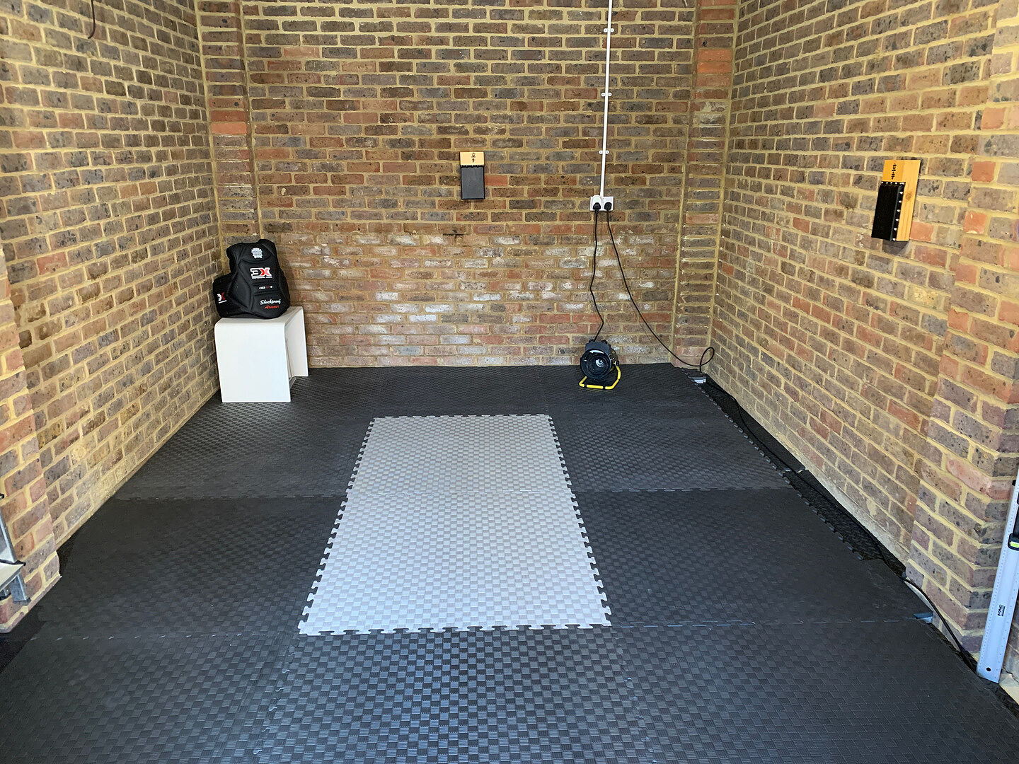 Black and grey EVA tatami mats fitted in Gary’s garage dojo.