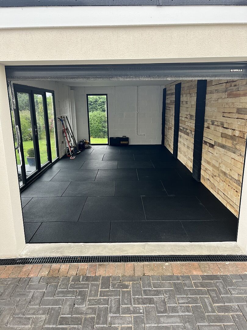 Black rubber tiles fitted inside Scott’s garage, viewed from the open entrance.