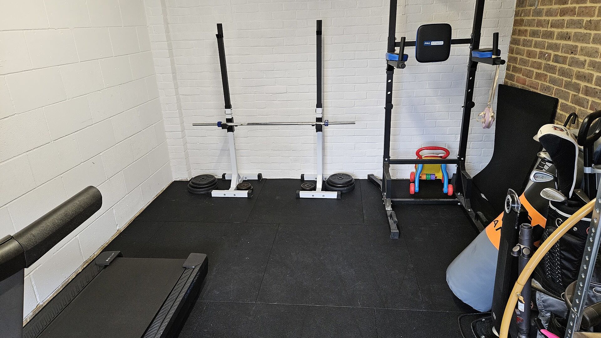 Black rubber tiles fitted across Maz’s garage gym floor.