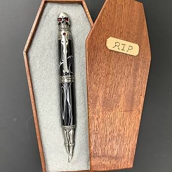 An antique pewter Skull fountain pen store with barrels of Black Poisonwood. Pen comes with 1 ink cartridge and an ink pump.